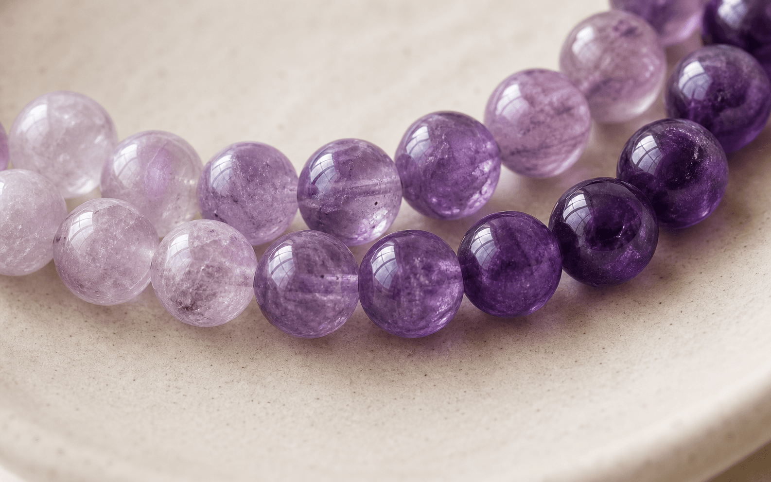 Round amethyst beads ranging from pale lilac to deep violet